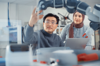 Horizontal Arabic Female Future Engineer Looks At Work Of Skilful Developer. Asian Man Explains Core Principles And Examins .png